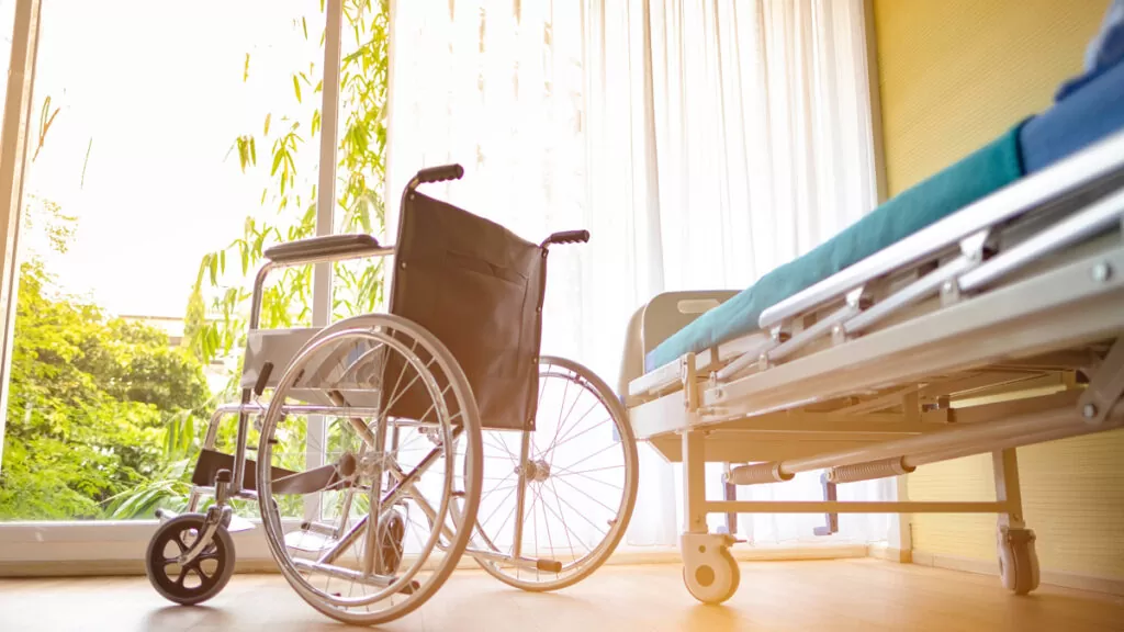 A wheelchair next to a hospital bed in an El Paso home.